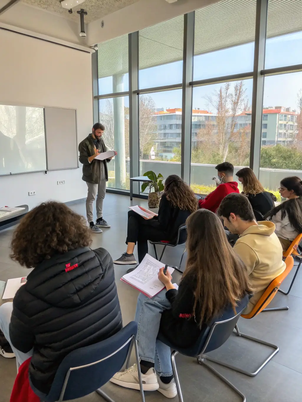 A group of trainees learning how to operate a professional video camera during an audiovisual workshop in a community center in Normandy, France.